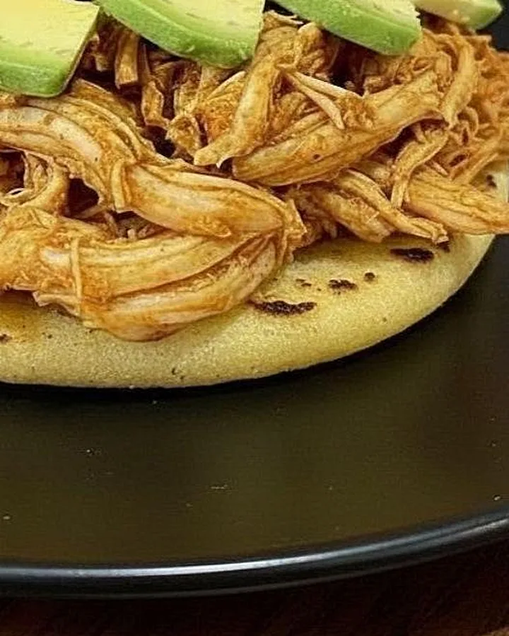 Carne desmechada sobre la arepa